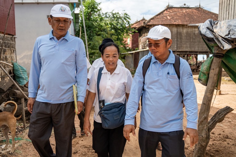 Three health workers survey Chi Pray Village in Cambodia before conducting leprosy screening.